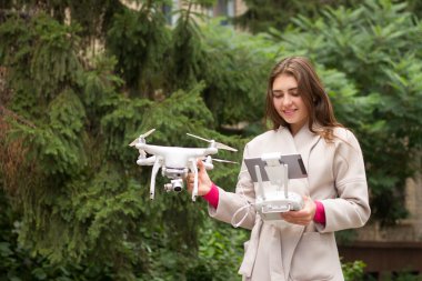 Ayakta ve holding dron genç kadındır. 