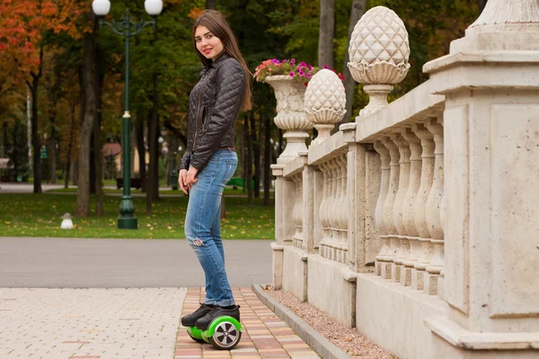 Szczęśliwa dziewczyna stojąc na hoverboard lub gyroscooter odkryty. — Zdjęcie stockowe
