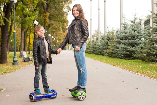 Młoda Mama i syn jazda transportu osobistego eco hoveboard. — Zdjęcie stockowe