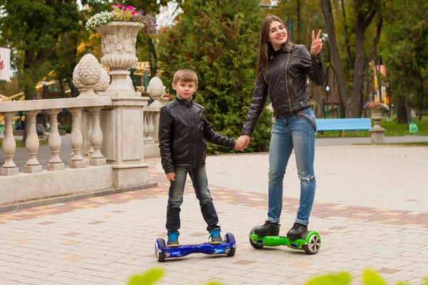 Młoda Mama i syn jazda transportu osobistego eco hoveboard. — Zdjęcie stockowe