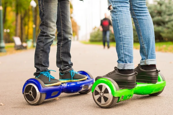 Stóp dziewczynka i chłopiec jazda elektryczny mini segway na świeżym powietrzu w parku. — Zdjęcie stockowe