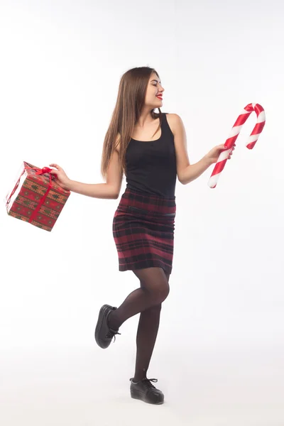 Young woman portrait hold gift in christmas color style . Smiling happy girl on white background.New year greetings . — ストック写真