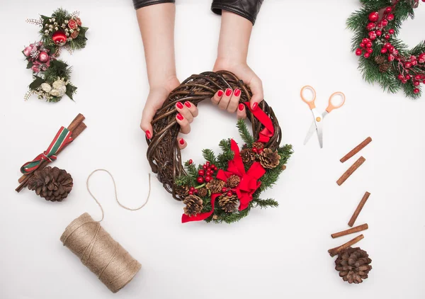 Kız Noel çelenk kırmızı kurdele ve dekorasyon ile yapma — Stok fotoğraf