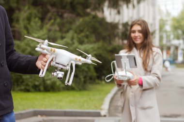Adam kız dron kontrol etmek için öğretir. Hava video ve fotoğraf makinesi. 