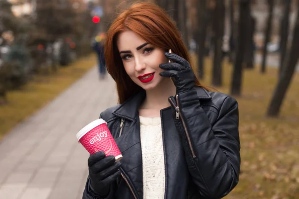Retrato de chica con una taza de café caliente y con teléfono móvil . — Foto de Stock