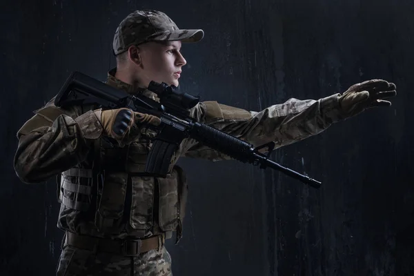 Un giovane soldato con un'arma tra le munizioni. Airsoft - un gioco per veri uomini . — Foto Stock