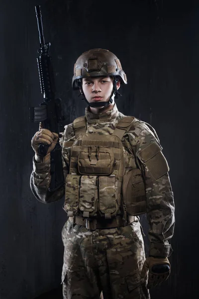 Nuestra defensa, nuestro ejército. Los soldados - nuestro orgullo. Joven soldado sosteniendo un arma en la munición . — Foto de Stock