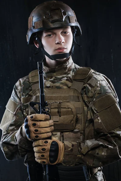 Retrato de un joven soldado. Las manos sosteniendo el rifle. Orgulloso y seguro bastante completo . — Foto de Stock
