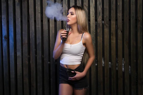 Schöne blonde Mädchen produzieren Rauch. sinnliches junges Mädchen verdampft. — Stockfoto