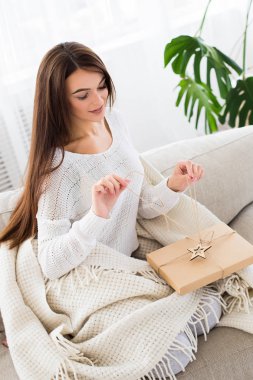 Günaydın. Onu oturma odasında kanepede sabah bir hediye açılış çekici esmer kadın.