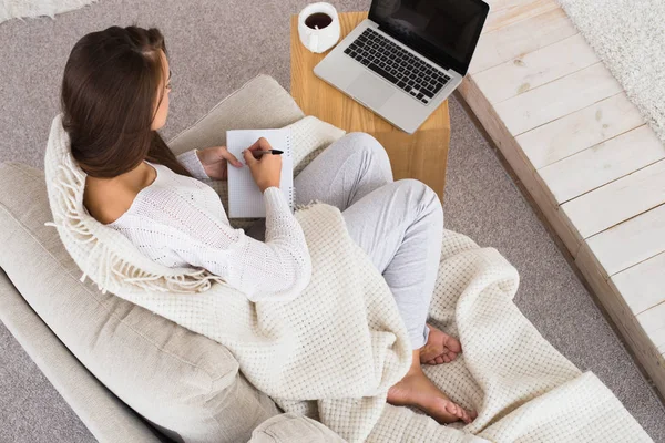 Pas le temps de se reposer. Belle femme travaille à la maison. Femme écrivant une lettre et regardant un film . — Photo