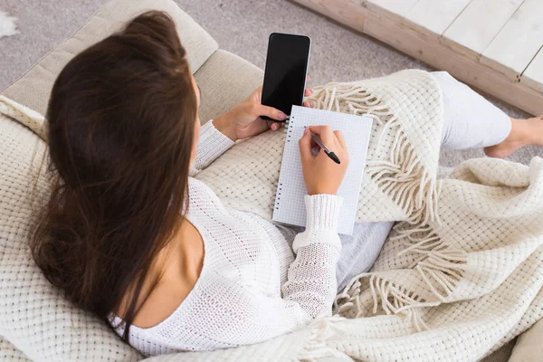 çekici esmer kadın denetim listesi ve evde otururken cep telefonu kullanma yazmak.