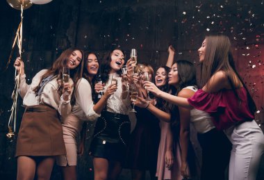 Kızlar bir yeni yıl dilek ve şampanya içmek olun. Çekici kız bardak şampanya ile dans mutlu grup