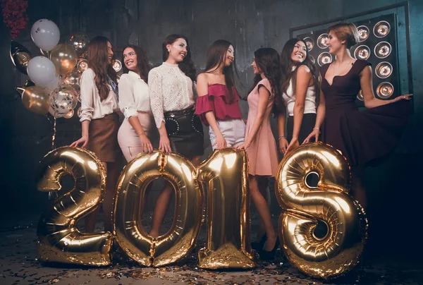 Piękne dziewczyny komunikować się ze sobą i szczęśliwy uśmiechający się. Christmas party w klubie Gold balony numery 2018 r. Christmas party. Hew rok 2018. — Zdjęcie stockowe