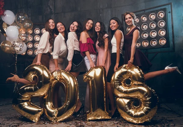 Feliz grupo de mujeres jóvenes. ¡Se acerca el nuevo año 2018! Grupo de jóvenes alegres llevando números dorados. Feliz Año Nuevo para ti ! —  Fotos de Stock