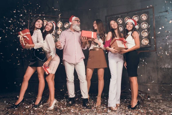 Happy New year with presents and Santa Claus.  man in Santa's hat carrying Christmas bengal lights with beautiful girls in club with gold confetti celebrate New Year and Christmas party 2018 — Stock Photo, Image