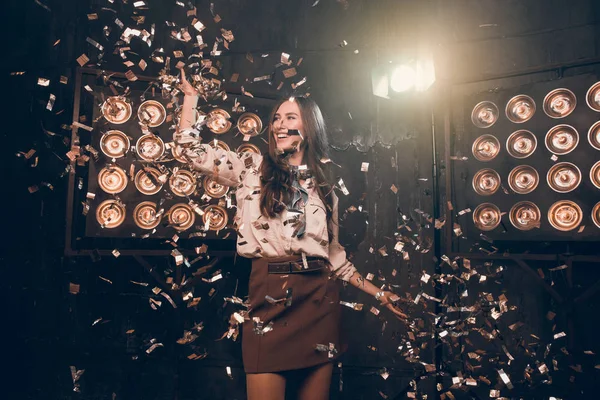 Beautiful girl in confetti happy dancing and celebrate New Year.  Merry Christmas 2018!