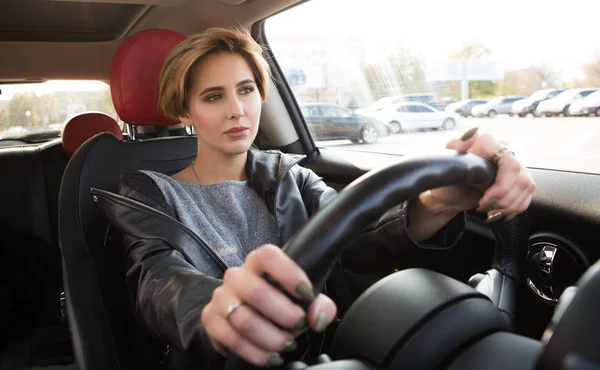 Hermosa chica casual conducir un coche y mirando en la carretera. Coches de conducción seguros. Concéntrate mientras conduces el coche — Foto de Stock