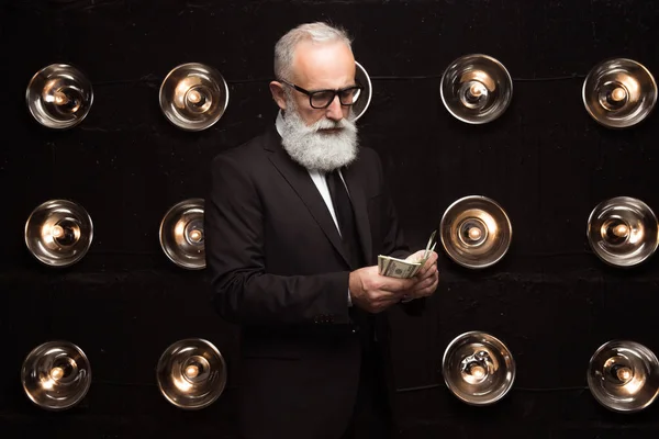 Ein seriöser reicher Geschäftsmann zählt Geld und Dollar. Gehalt für ihn Arbeiter. Zahltag, Aufstieg und Geldpreis. Bärtiger Geschäftsmann zählt viel Geld — Stockfoto