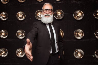 Elini ortağına el sıkışma için veren işadamı. Mutlu iş adamı ile ortak yeni bir anlaşma yapmak. Bir mülkiyet satın alma veya yeni iş veya anlaşma ile başlayan yeni sözleşme.