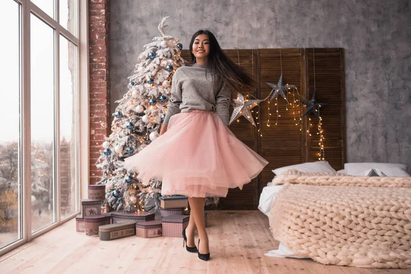 Рождество, зимние праздники и люди концепция - молодая азиатская девушка танцует возле елки — стоковое фото