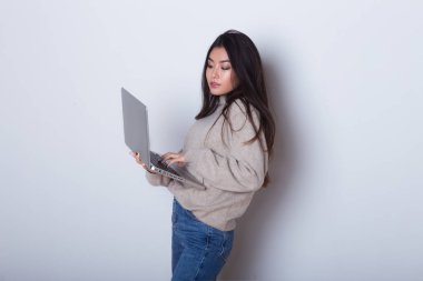 Beyaz arka plan üzerinde izole duran dizüstü bilgisayarda çalışan moda iş kadın portresi. Bilgisayar ve internet kullanma yeni office
