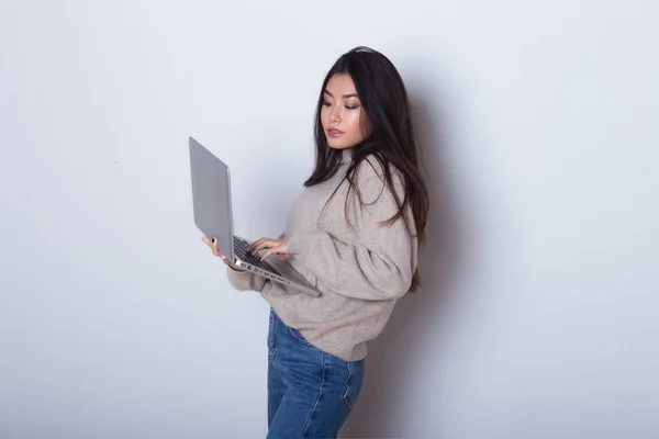 Портрет модной бизнес-женщины, работающей на ноутбуке, находясь в изоляции на белом фоне. Использование компьютера и Интернета в новом офисе — стоковое фото