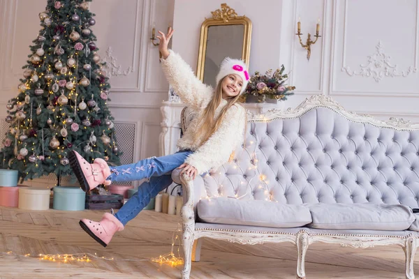 Tamam gesticulating ve Noel ağacı arka plan gülümseyen küçük kız. Şık ve modaya uygun giysiler. Neşeli Noel ve mutlu yeni yıl! — Stok fotoğraf