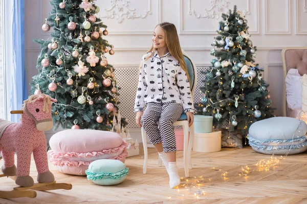 Gelukkig kerstfeest - mooi meisje met kerstcadeau. Kerstversiering in de kinderkamer. — Stockfoto