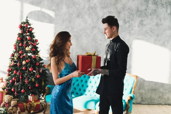 Time to presents. Couple in love give gifts to each other and happy smiling. Elegant wearing couple celebrate Christmas. Christmas morning with my biggest love. — Stock Photo, Image