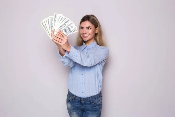 Bild einer glücklichen jungen Geschäftsfrau, die über einer grauen Wand steht und Geld hält. Kamera gesucht. — Stockfoto