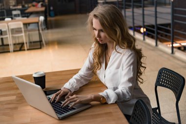 Bir kadın onu laptop üzerinde çalışıyor. İnternette bilgi arıyor. Çalışma günü.