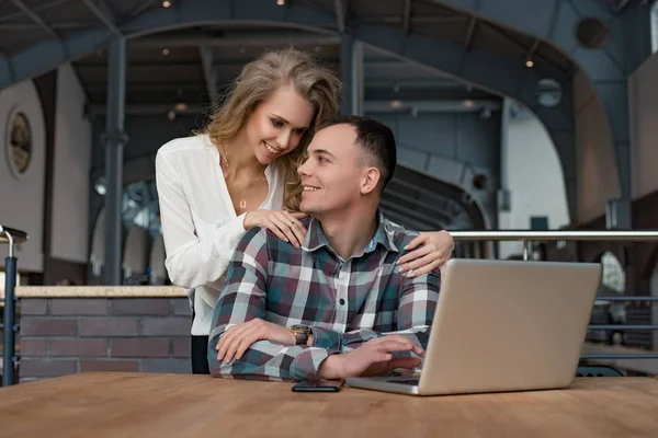 Un couple travaille sur l'ordinateur portable. Ils sont heureux et câlins. L'homme et la femme discutent. . — Photo