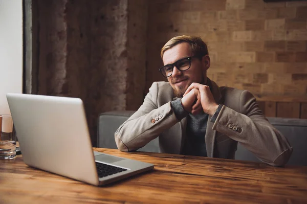 Hombre de negocios está hablando por vídeo de comunicación con su colega en el portátil y sonriendo . —  Fotos de Stock