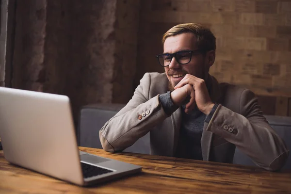 Hombre de negocios está hablando por vídeo de comunicación con su colega en el portátil y sonriendo . —  Fotos de Stock