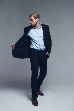 Şık ve kendinden emin. Öte yandan pantolon cebine attı ve ceket yaka tutarak iş kişinin tam uzunlukta bir portre.