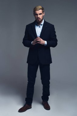 Kendine güvenen ve düşünme. Birlikte gri arka plan önünde duran el ele tutuşarak işadamı tam uzunlukta bir portresi.