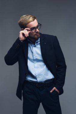 Şık ve kendinden emin. Öte yandan pantolon cebine attı ve gözlük tutarak iş kişinin bir portre.