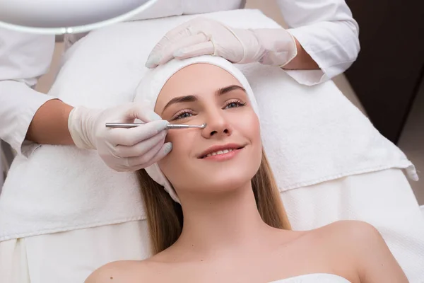 Tieni la tua bellezza! Bella donna ottenere la pulizia della pelle e il trattamento del viso al salone di bellezza cosmetologo si prende cura del suo viso . — Foto Stock