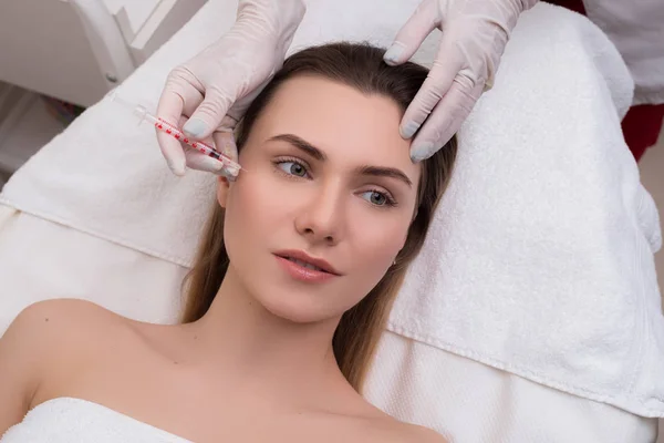 See after your skin! Young pretty woman getting injection in her face in order to lift her skin and have no wrinkles. — Stock Photo, Image
