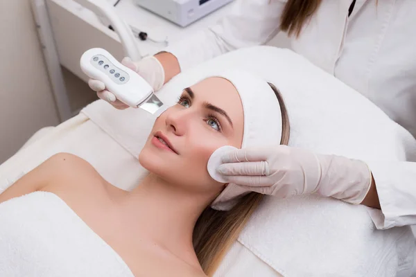 ¡Conserva tu belleza! Chica joven galante bien-agraciada conseguir descamación facial como el procedimiento médico en el salón de SPA . — Foto de Stock