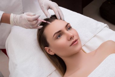 Her zaman genç olmak! Yordamlar için masaya yalan onun yüzüne enjeksiyon almak çekici Bayan portresi yan görünümü. 