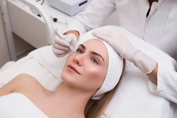 Prenditi cura della tua giovinezza! Pulizia Blackhead sul viso della donna durante il trattamento facciale presso la clinica di bellezza. Giovane signora che viene fatto il trattamento dell'acne con un aiuto di strumento meccanico . — Foto Stock