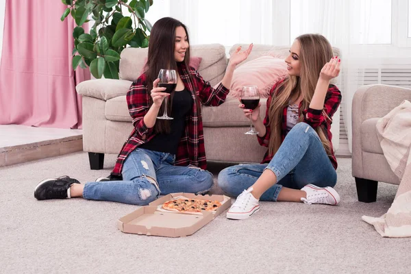 Genießen Sie Ihre Freizeit mit Freunden! zwei stilvolle junge charmante Frauen, die zu Hause plaudern und essen. — Stockfoto