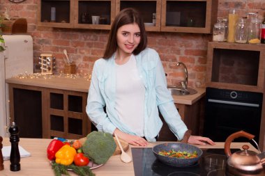 Senin görevin, asla unutmam gerçek güzellik sağlıktır! Öğle yemeği yemek yaparken mutfakta, olmanın kamera için poz zeki büyüleyici kadın.