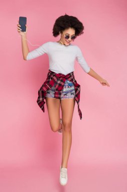 Bir tüy kadar hafif! Müzik ve biraz atlama, iyi resim için poz büyüleyici güzel genç kız.