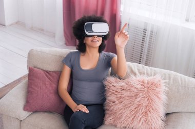 Her şeyi ile modern araçlar kolaydır! Evde soğutma ve unreal dünya dokunmadan güzel Afrikalı-Amerikalı genç kadın.