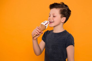 Kendiniz için zaman! Dondurma izole arka plan üzerinde duran, harika tadı nedeniyle memnun mutlu genç çocuk.