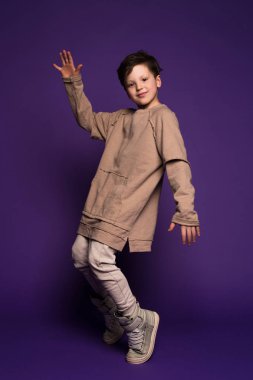 Bir kişilik tarzıdır! Çok güzel bir çocuk dans break, unsurları izole mor arka plan üzerinde moda giysiler giyen süre dans. 