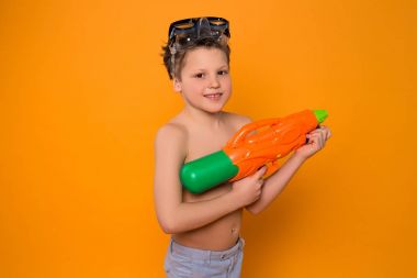 Eğer Oyunlar oyun daha eğlenceli hayattır! Küçük genç çocuk ile yalıtılmış turuncu arka plan üzerinde resim için poz kafasında koruyucu gözlük.